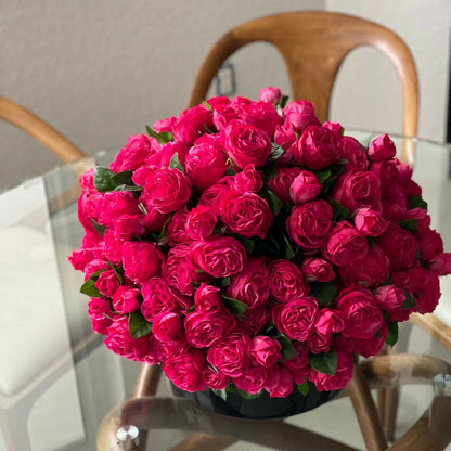 Dunkelrosa englische Rosen in schwarzer Glasvase
