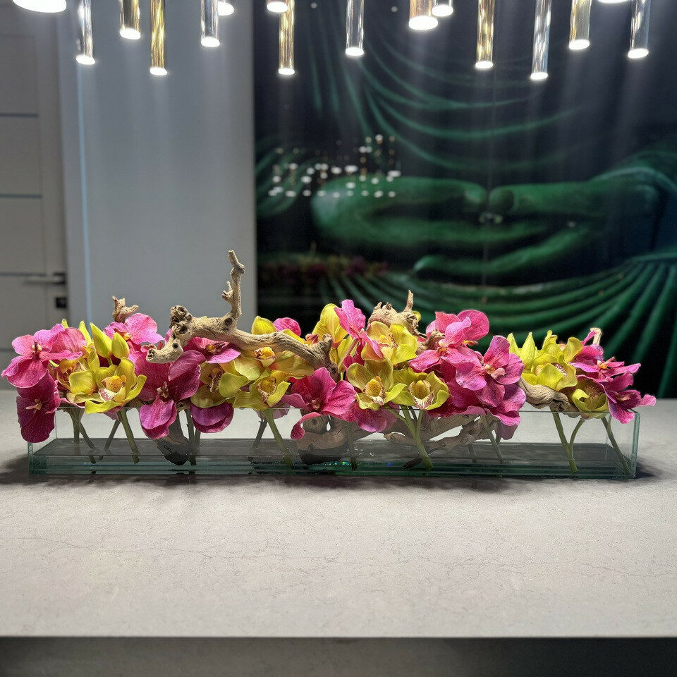 Moderne Hausvase aus Glas mit rosa Vanda-Orchideen und grünen Cymbidien