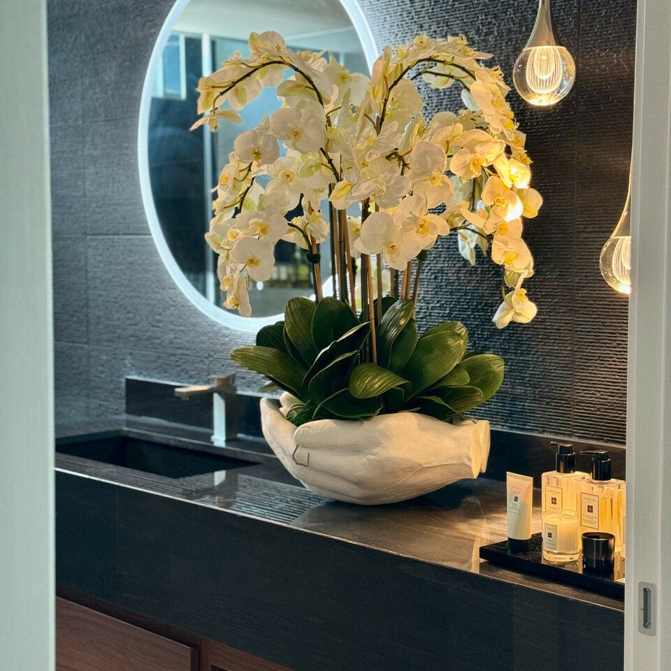 Weißer Phalaenopsis-Orchideenstrauß in Vase mit Skulptur "Offene Hände"